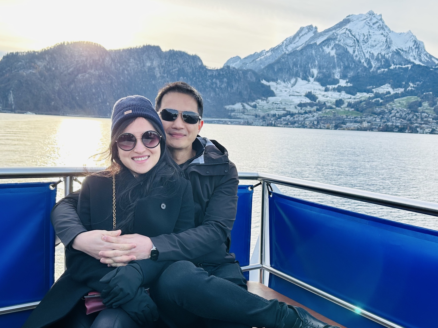 Frances and Francis together on a boat, with a lake and snow-covered mountains behind them