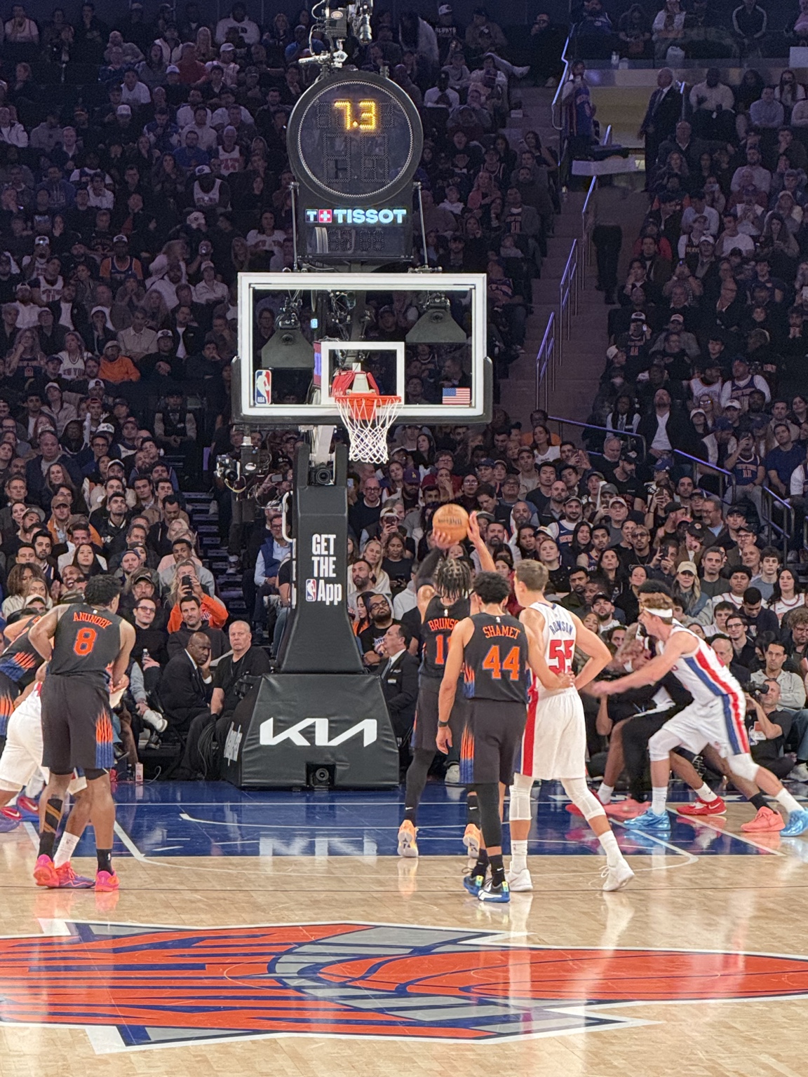 A Knicks player at the free-throw line with Knicks and Pistons players positioned around the lane.