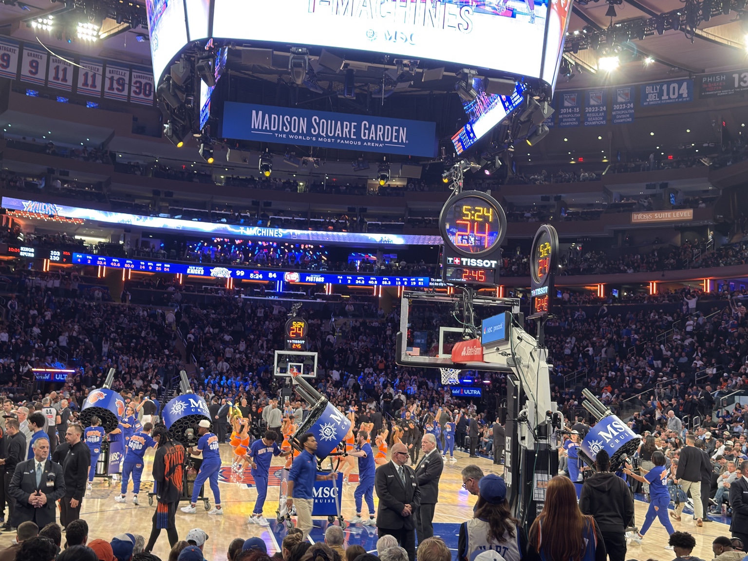 Arena staff with wheeled, multi-barrel T-shirt launchers on the court at Madison Square Garden.